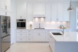 Modern kitchen remodel with white cabinets and marble countertops