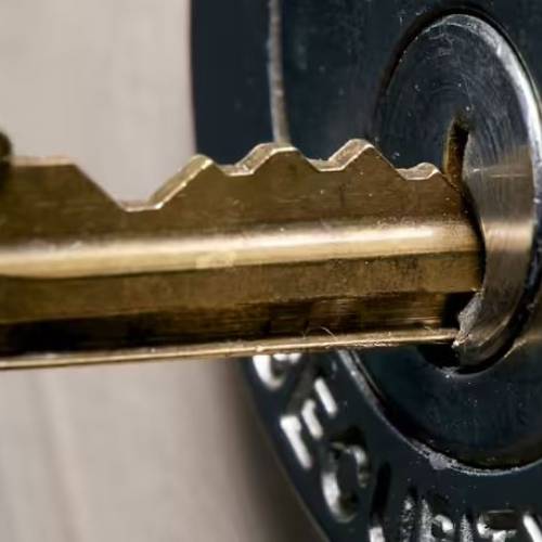 Ornate golden key on a dark blue velvet surface, symbolizing luxury and success